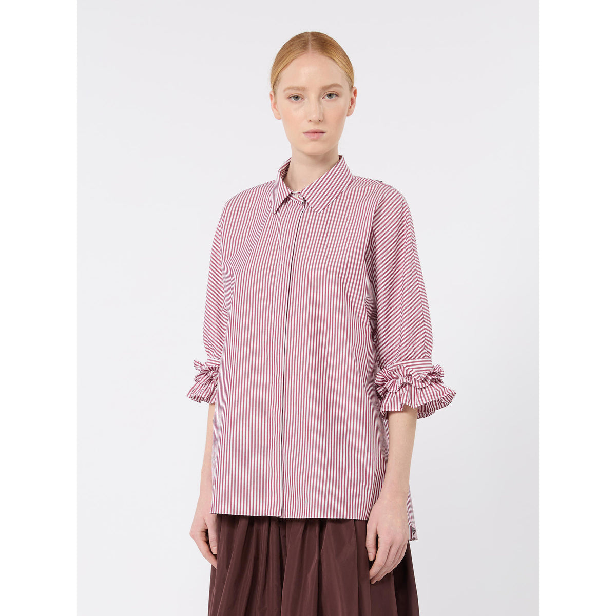 Woman wearing a pink and white striped shirt on a white background