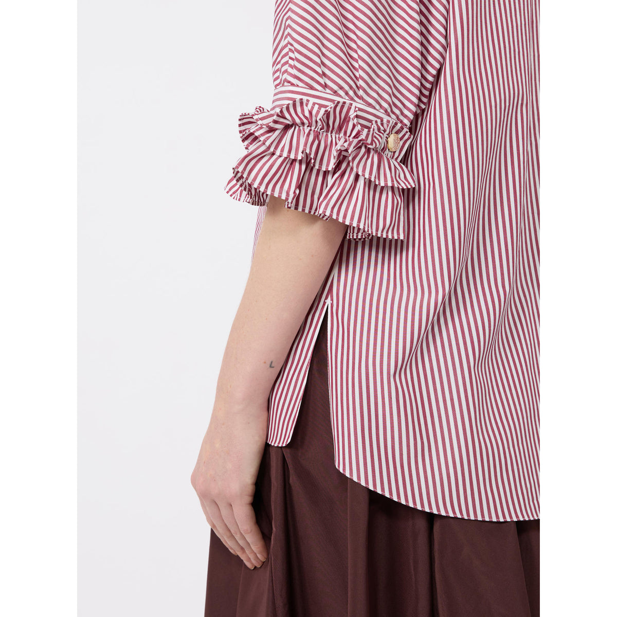 Red and white striped shirt with ruffled sleeves worn by a person on a white background