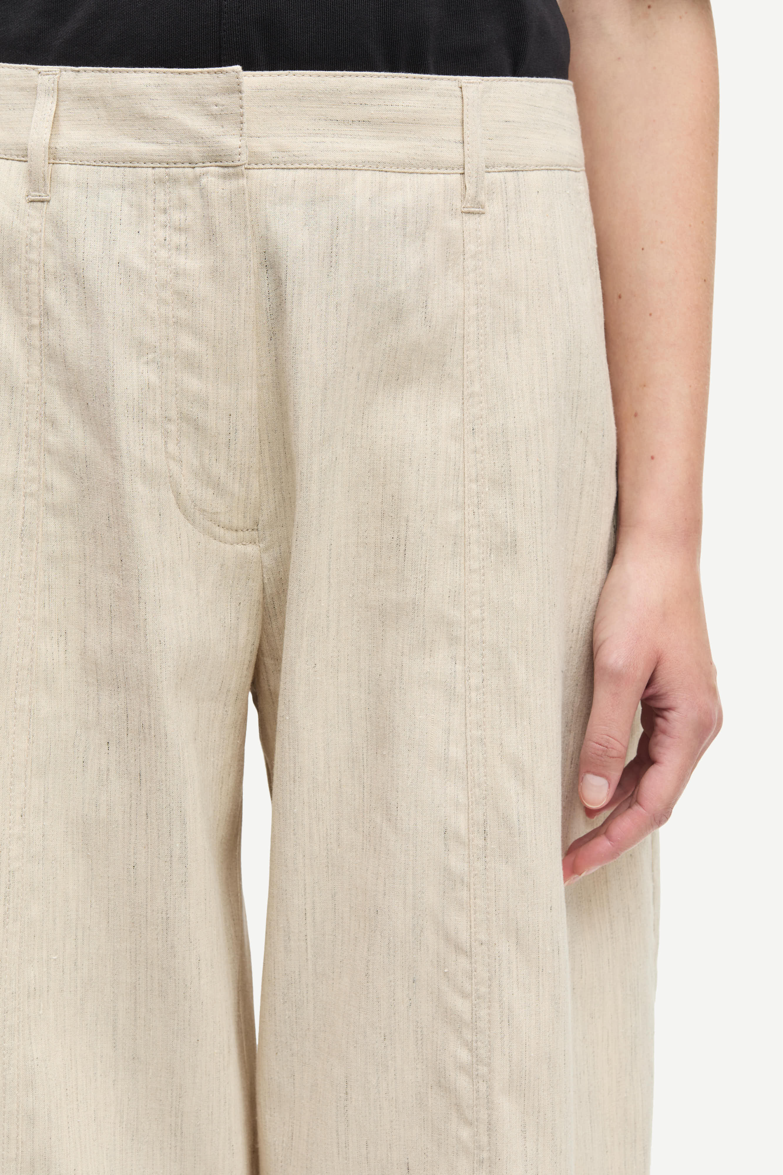 Beige pants worn by a person on a white background