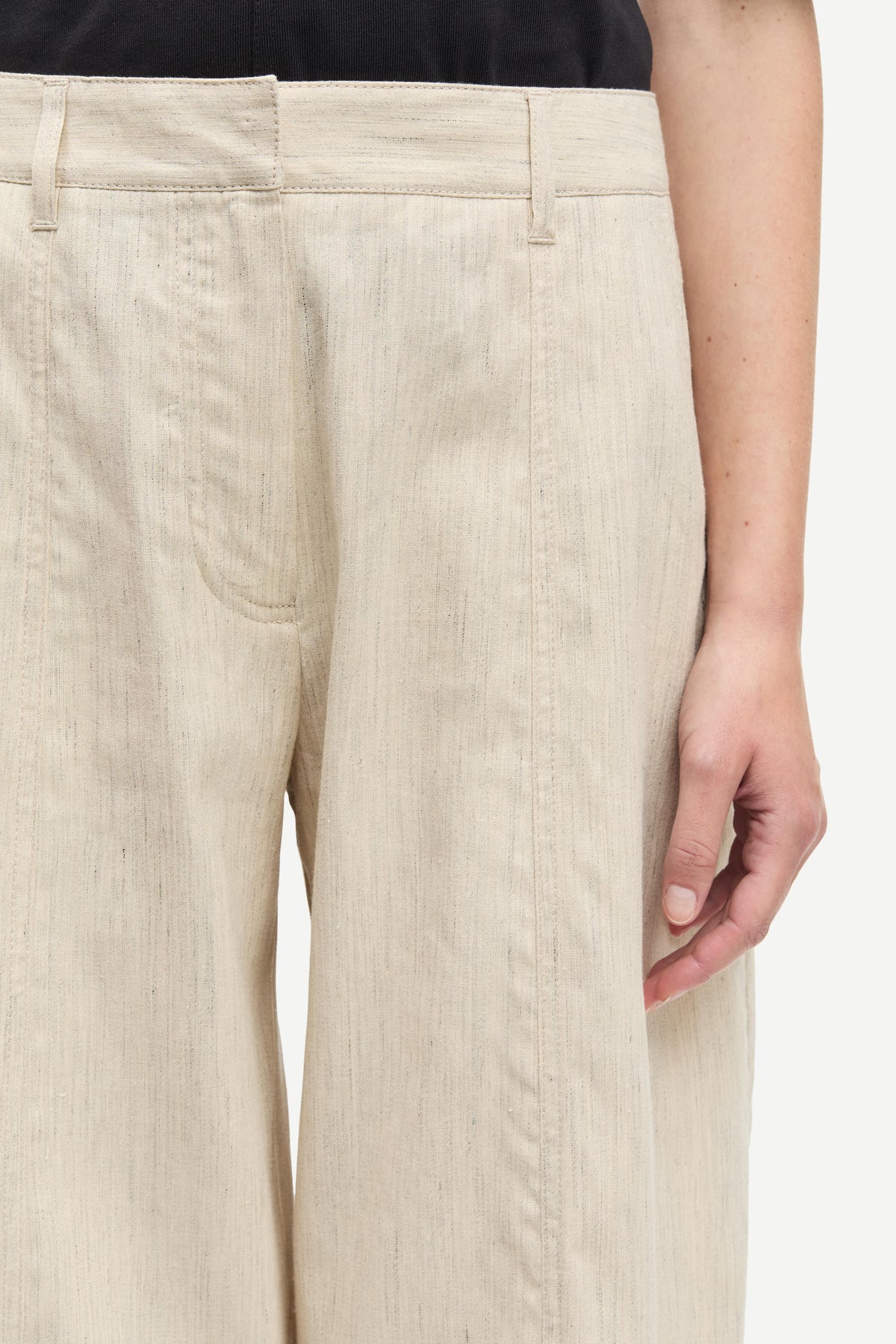 Beige pants worn by a person on a white background