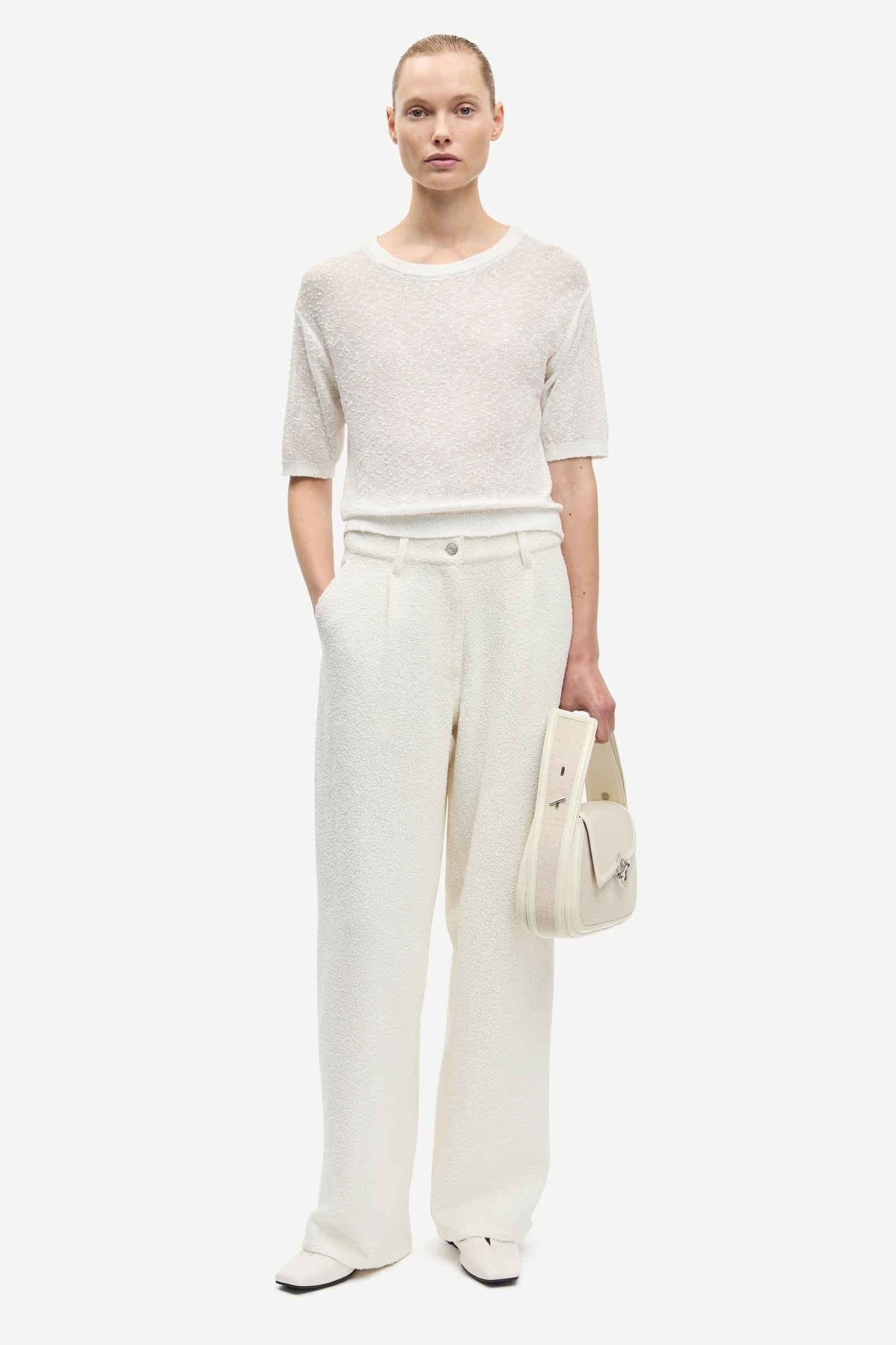 Woman wearing a white outfit with a plain background