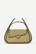 Handbag with a decorative handle on a light gray background