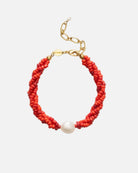 Red beaded bracelet with a pearl accent on a white background