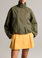 woman wears green jacket and yellow skirt
