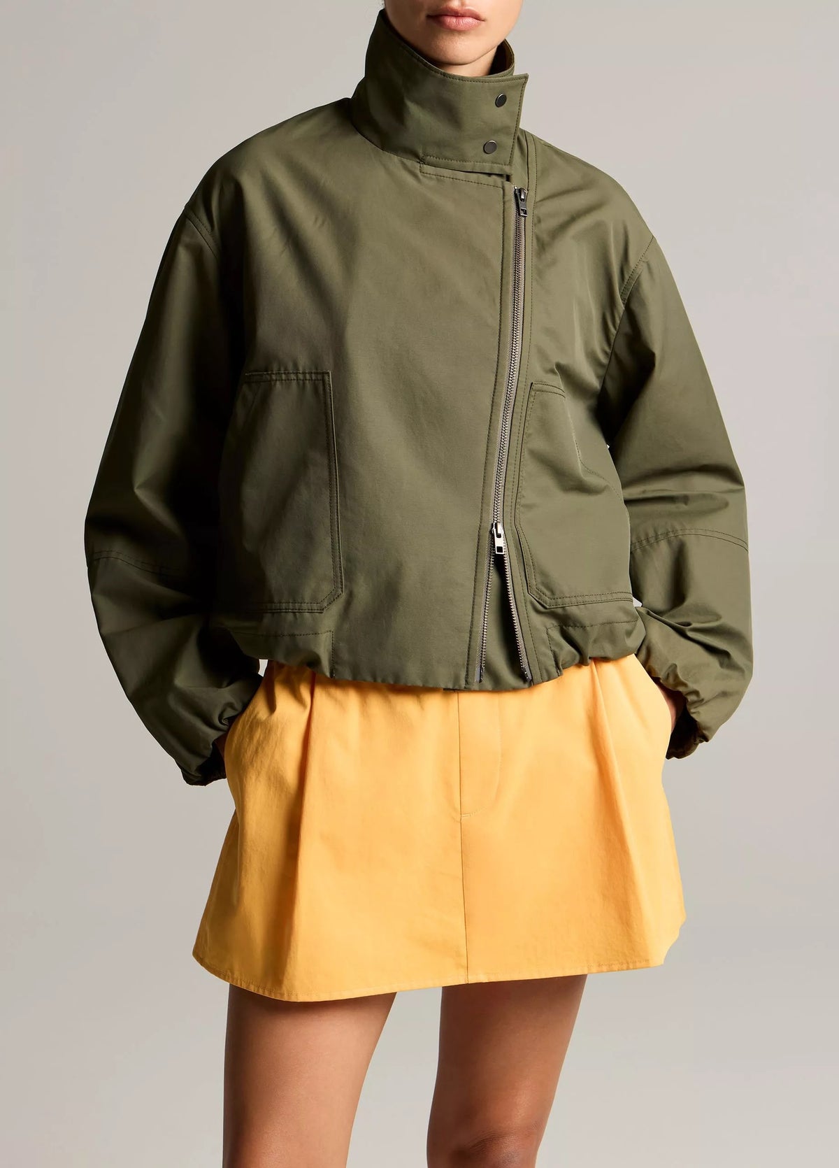 woman wears green jacket and yellow skirt