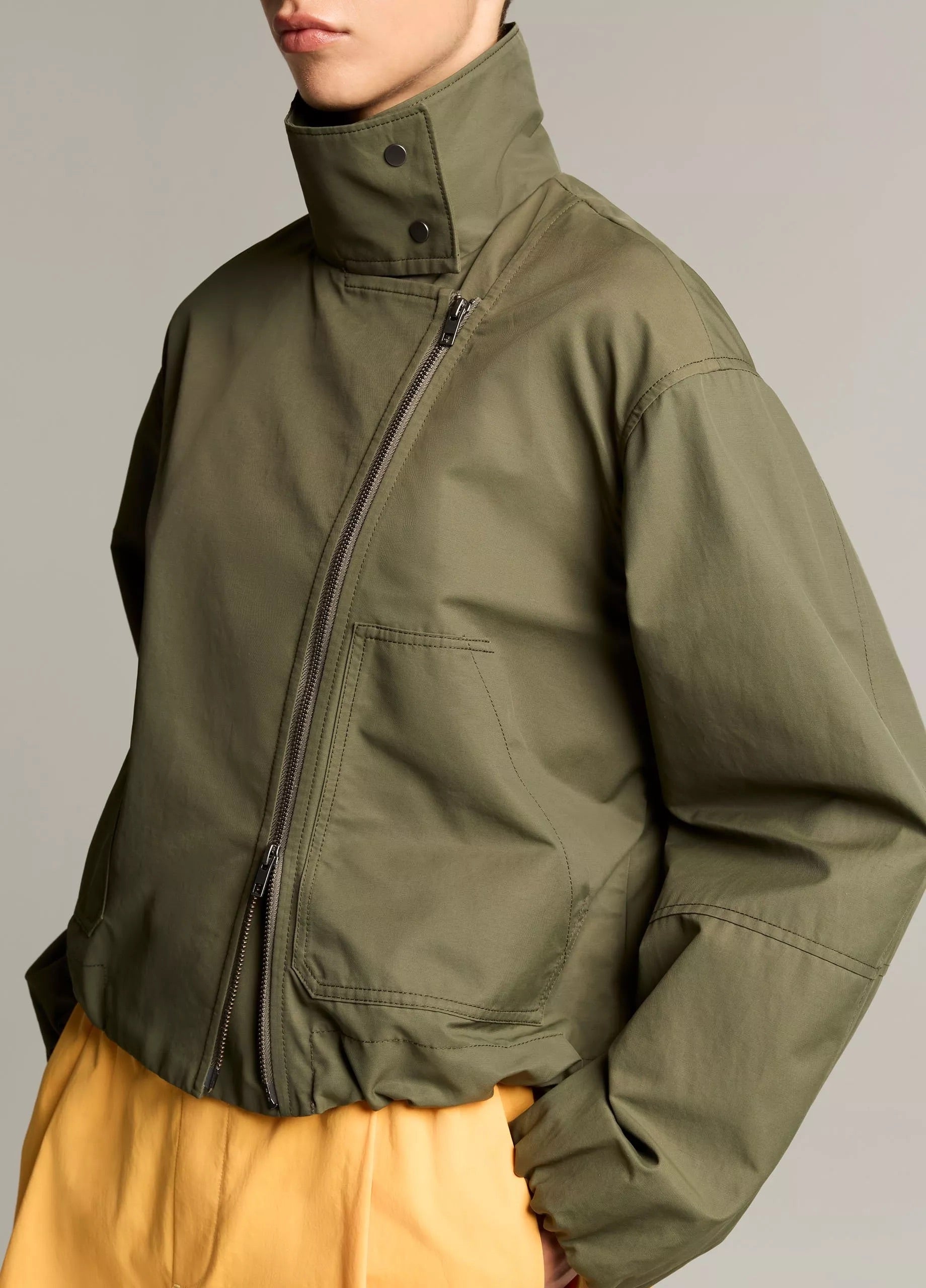 woman wears green jacket and yellow skirt