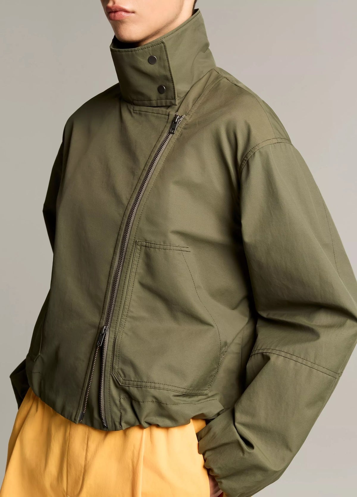 woman wears green jacket and yellow skirt