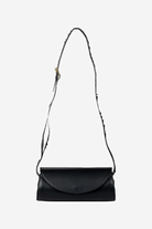 Black leather handbag with a strap on a white background