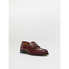 Brown leather loafer shoe on a light gray background