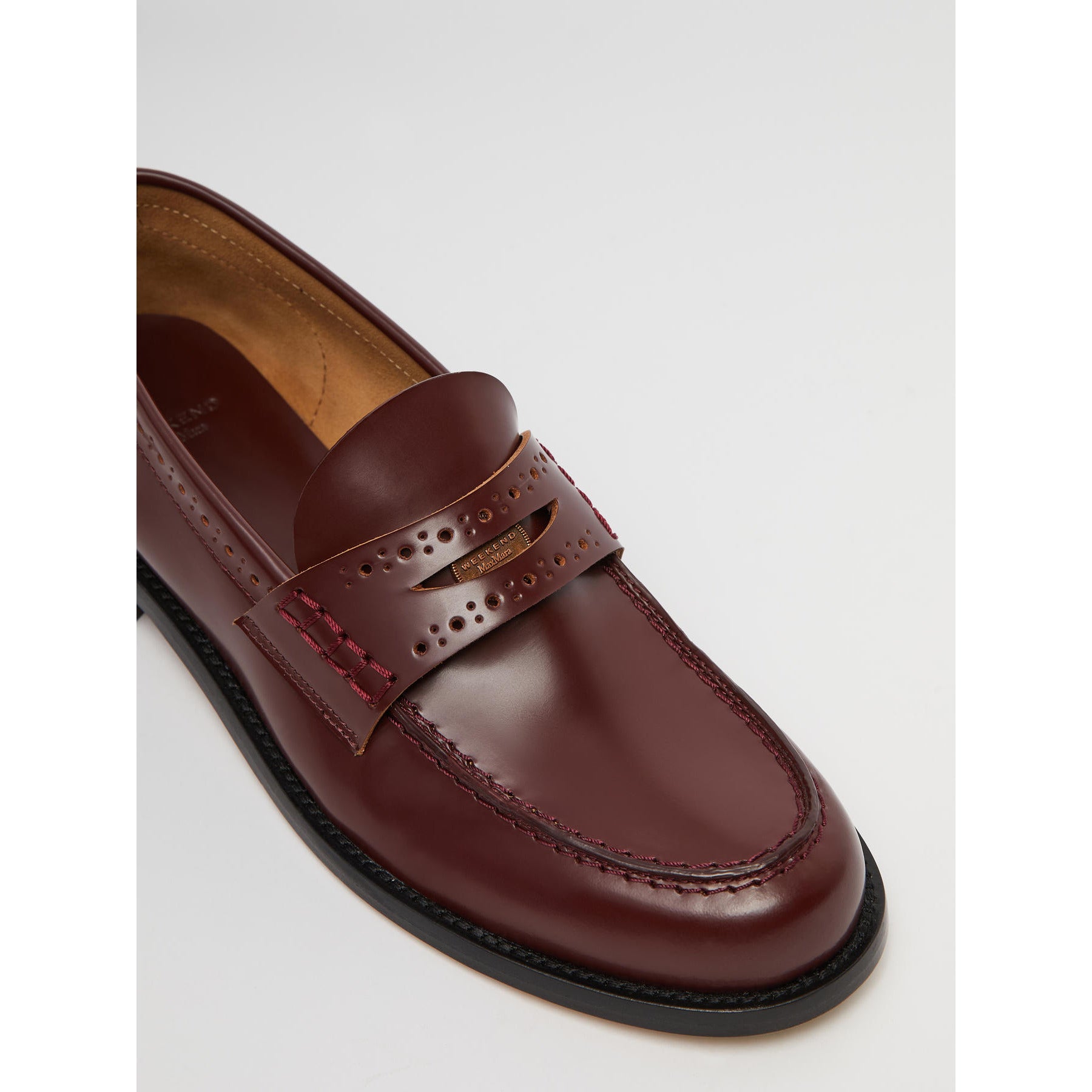 Brown leather loafer shoe on a light gray background
