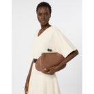 Woman holding a brown woven bag against a white background