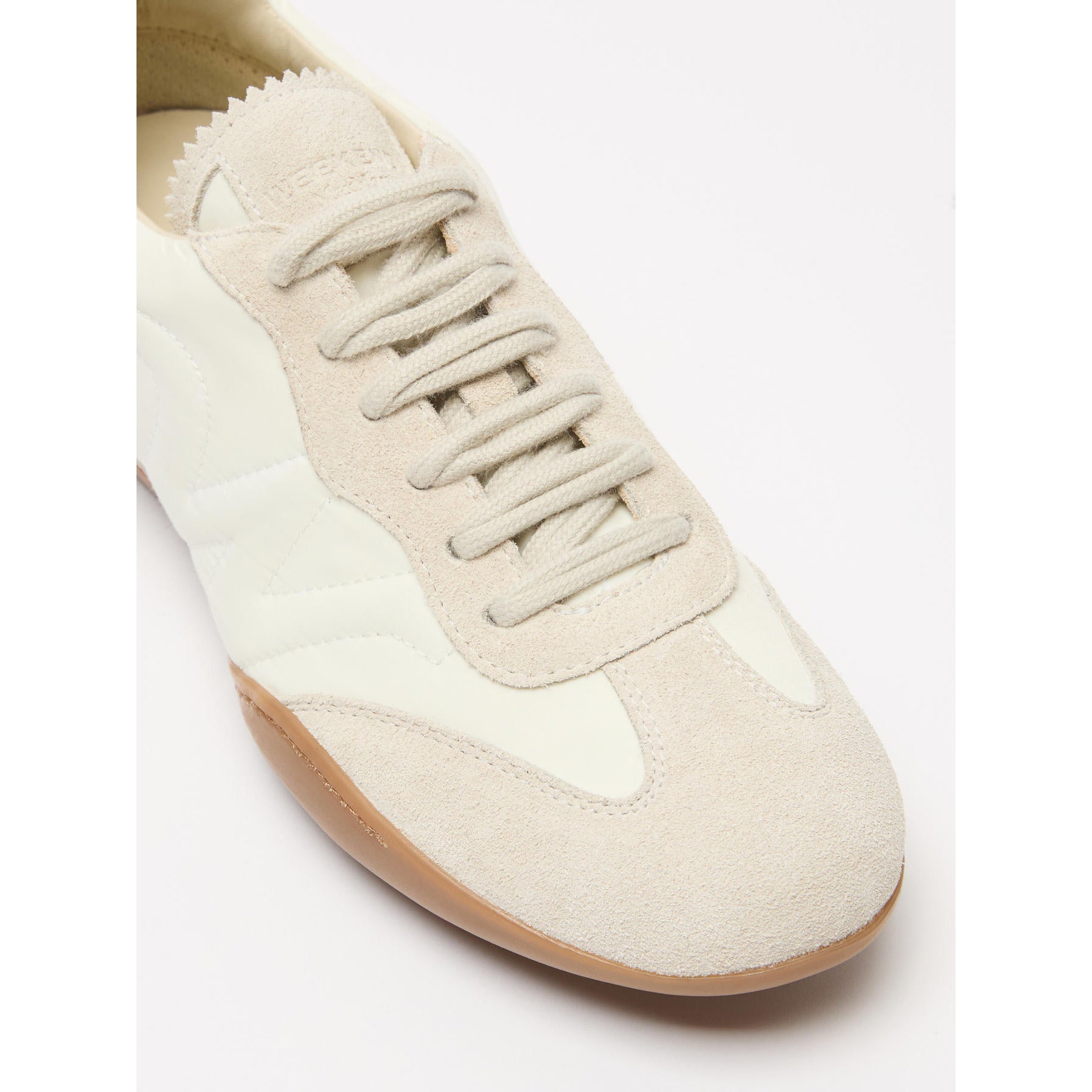 White sneaker with beige sole on a white background