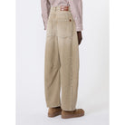 Person wearing beige wide-leg pants with a white background