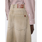 Beige pants with a brown leather belt and red and white striped shirt on a white background