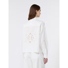 Woman wearing a white blouse with embroidery on a white background