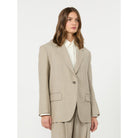 Woman wearing a beige suit on a white background