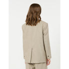 Person wearing a beige suit on a white background