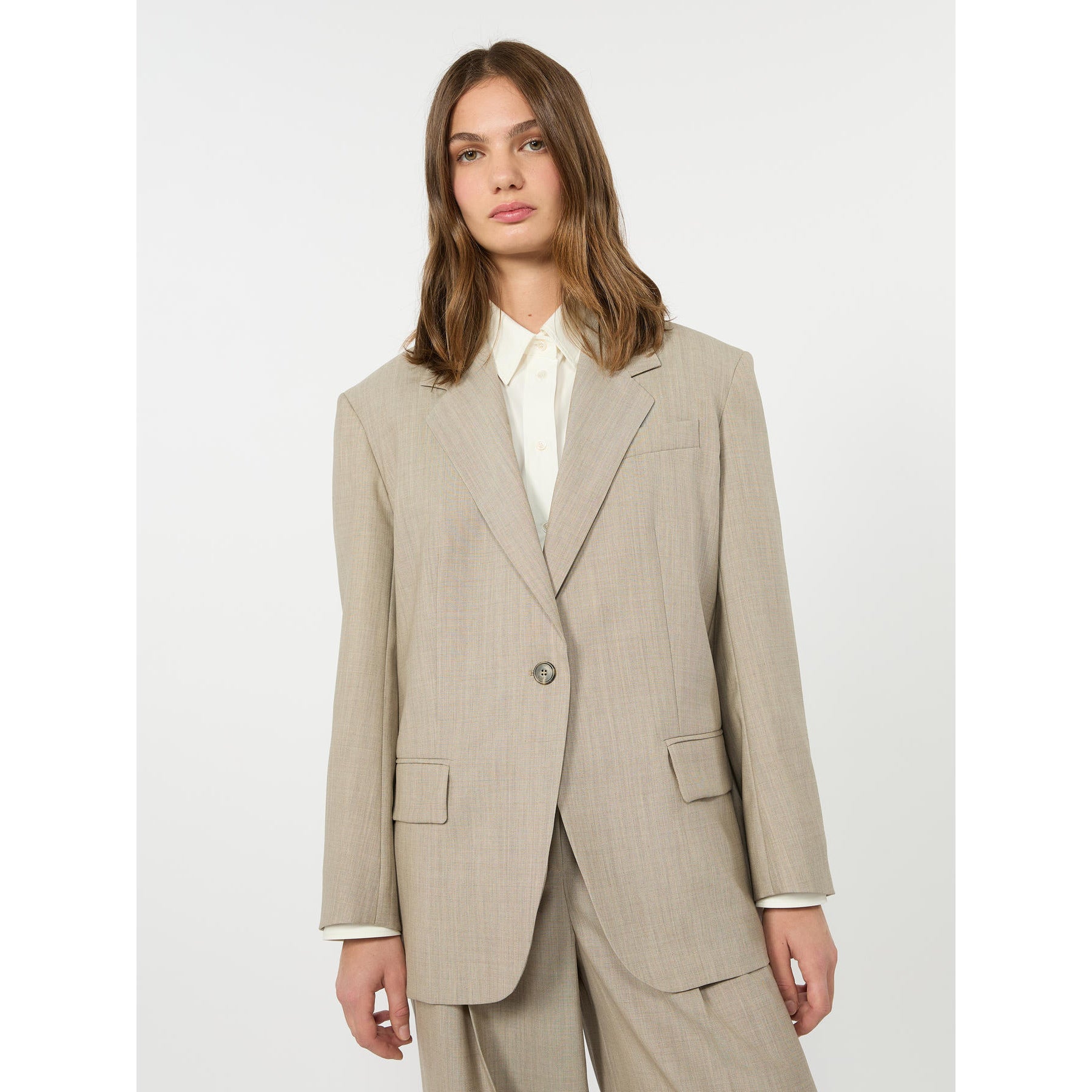 Woman wearing a beige suit on a white background