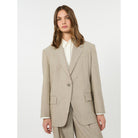 Woman wearing a beige suit on a white background