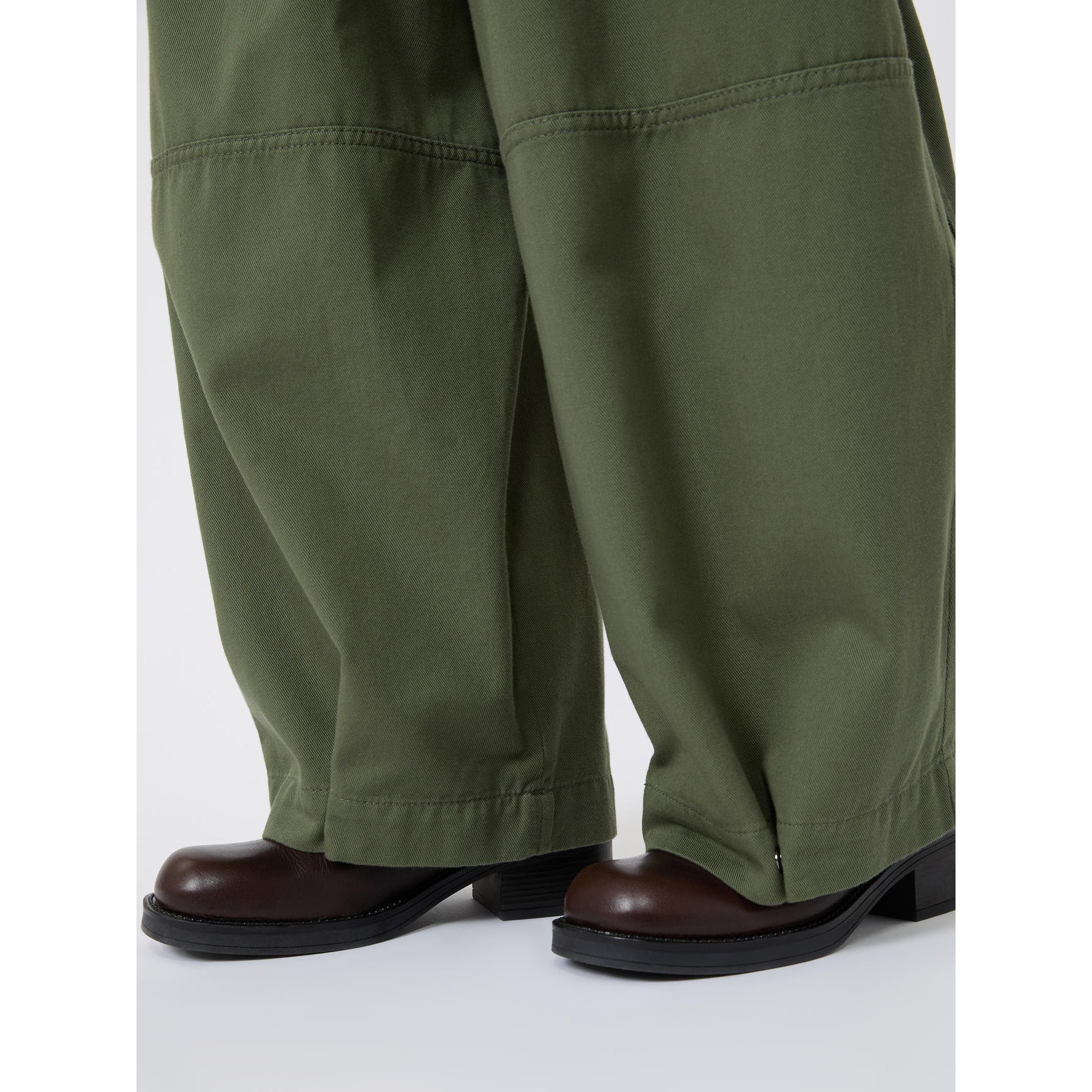 Green pants worn by a person on a white background
