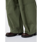 Green pants worn by a person on a white background