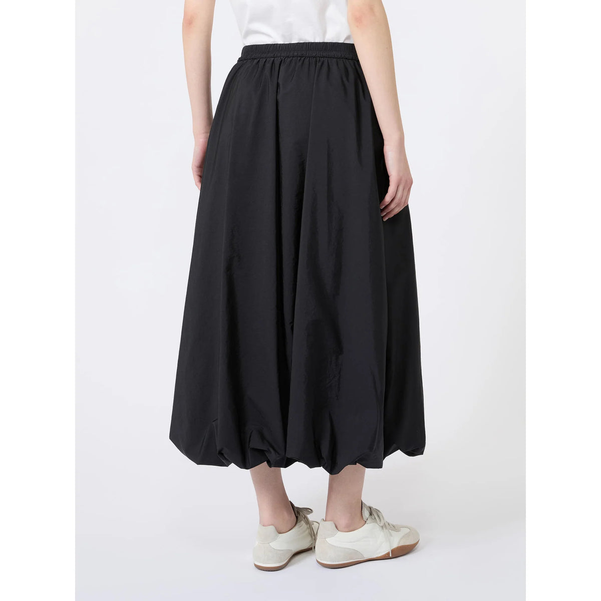 Person wearing a black skirt on a white background