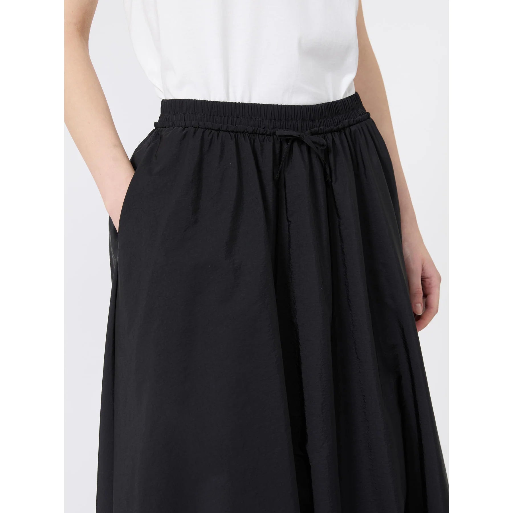 Black skirt worn by a person on a white background