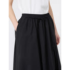Black skirt worn by a person on a white background