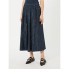Person wearing a dark blue patterned skirt on a white background