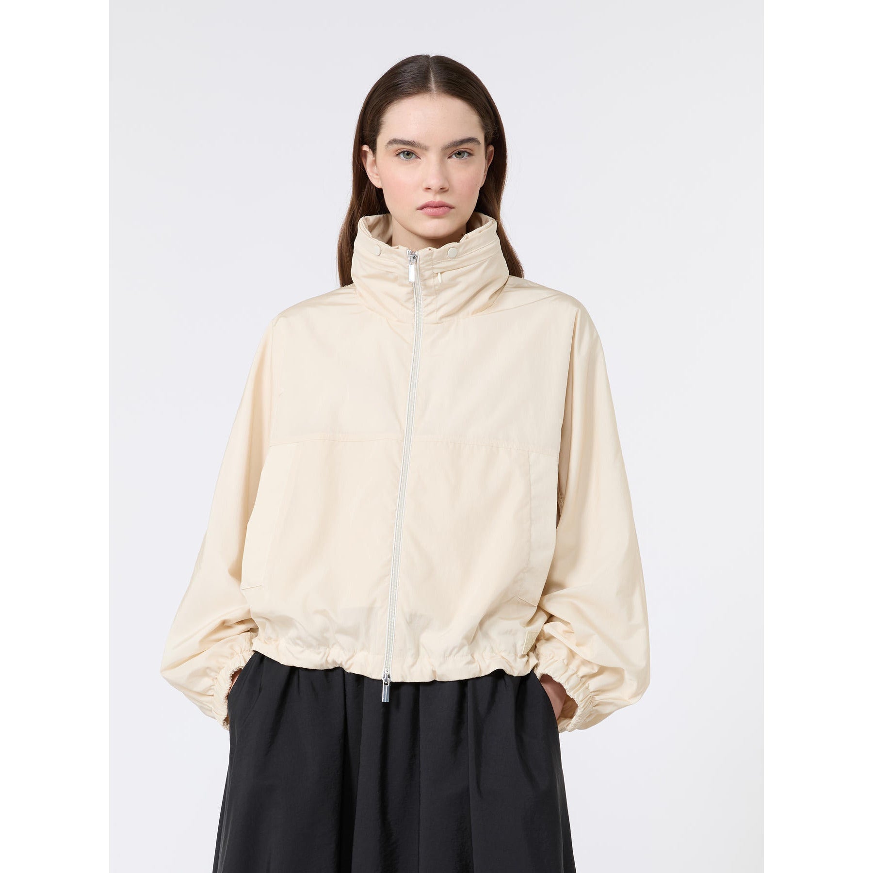 Woman wearing a beige jacket on a white background