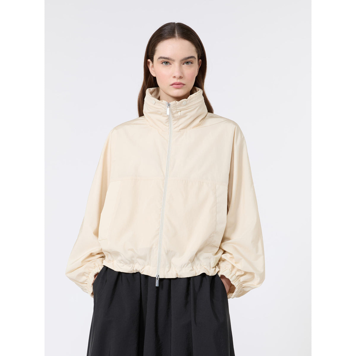 Woman wearing a beige jacket on a white background