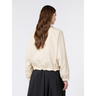 Woman wearing a beige blouse and black skirt on a white background