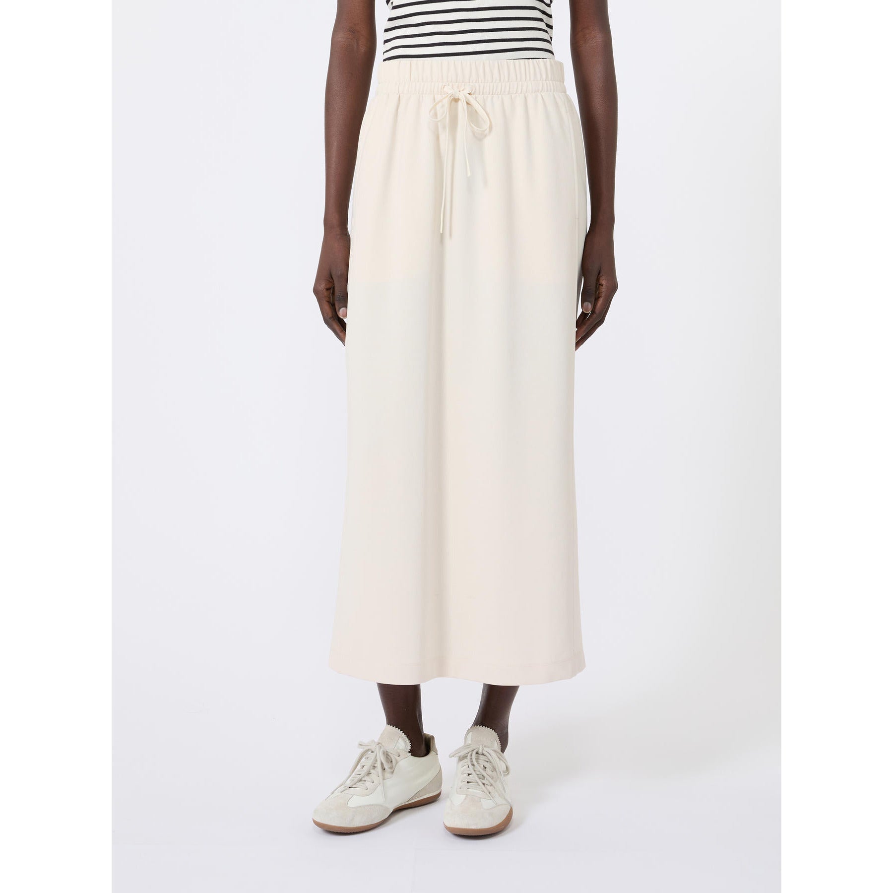 Person wearing a white skirt and striped shirt on a white background