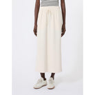 Person wearing a white skirt and striped shirt on a white background