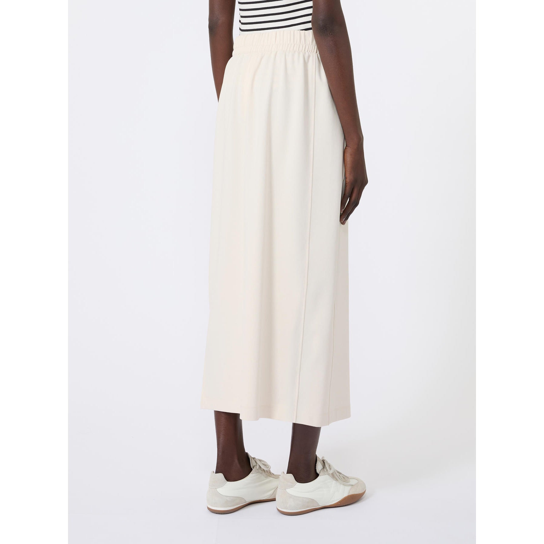 Person wearing a white skirt and striped top on a white background