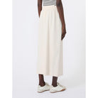 Person wearing a white skirt and striped top on a white background