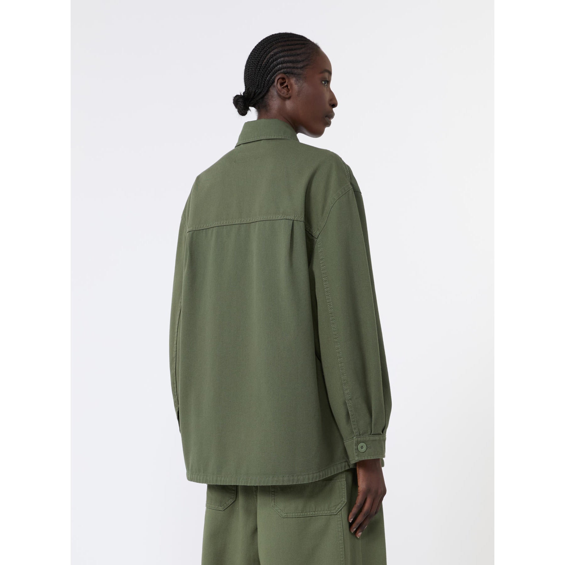 Person wearing a green jacket and pants on a white background