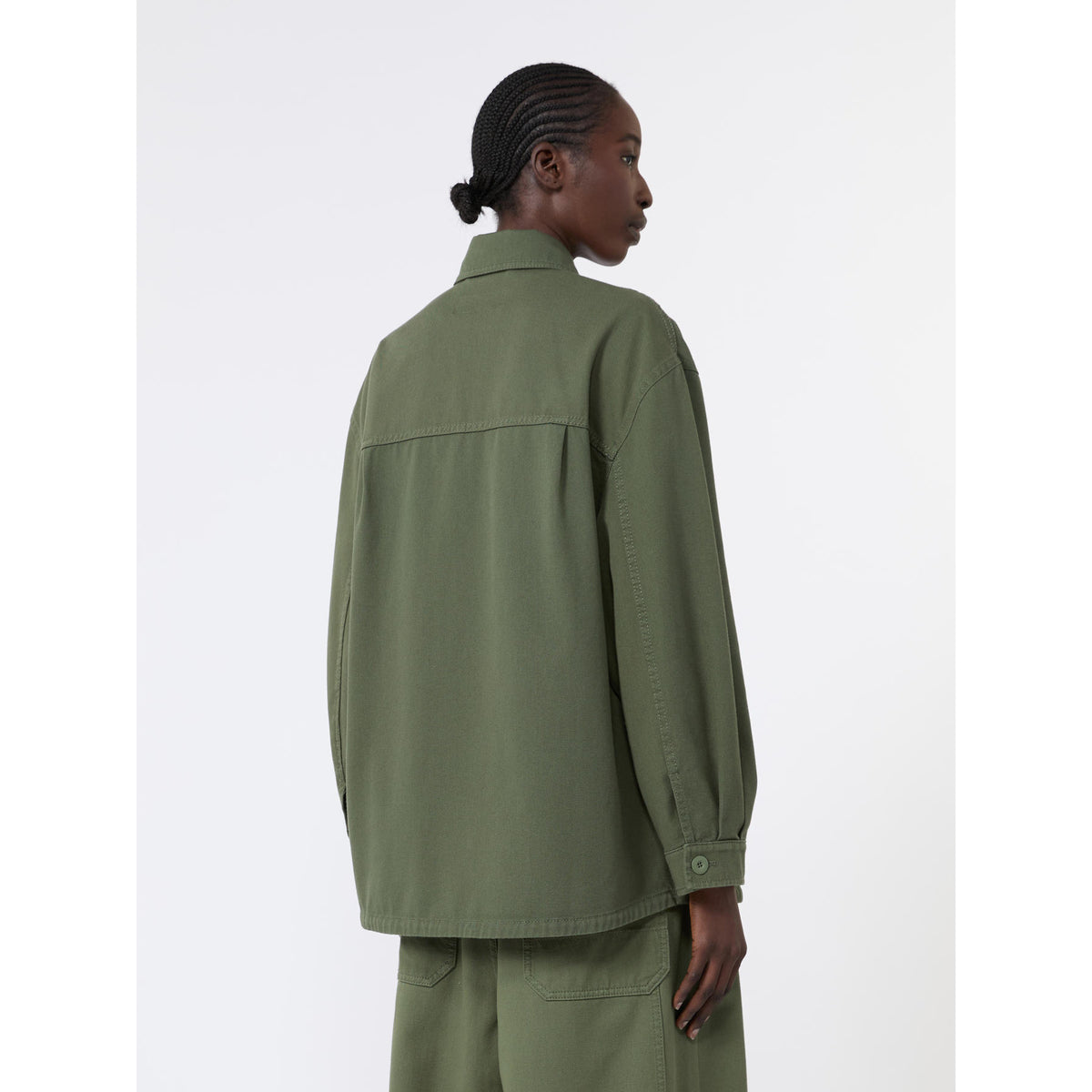 Person wearing a green jacket and pants on a white background
