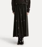 Black long skirt with button details on a white background