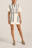 Person wearing a striped romper with a plain background