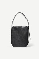 Black woven handbag with silver handle on a white background