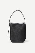 Black woven handbag with a metallic handle on a white background