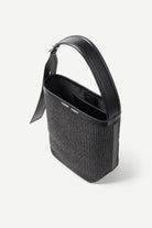 Black handbag with textured body and glossy handle on a white background